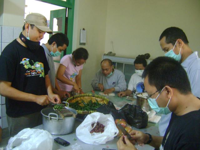 Scholastics and volunteers cutting chilis.