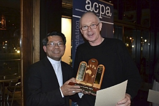 Eureka Street editor Michael Mullins receives the award from Bishop Vincent Long at the awards dinner. 