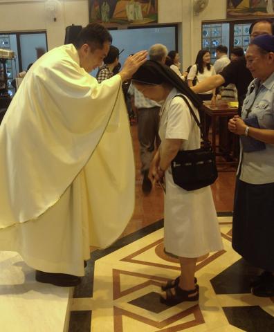 Fr Clement Tsui SJ blesses a Catholic after his ordination on August 22, 2015. (Photo by Raymond Leong)