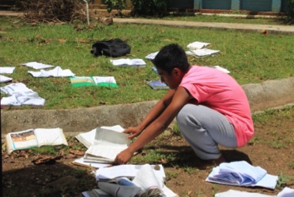 A student works to dry books that were damaged in the typhoon.